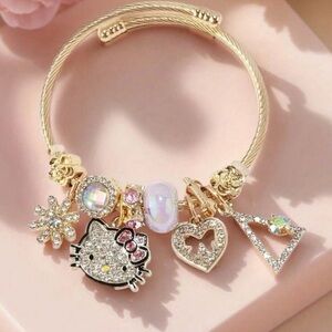 Hello Kitty Gold Charm Bracelet with Pink and Zirconia Accents. Silver is sold
